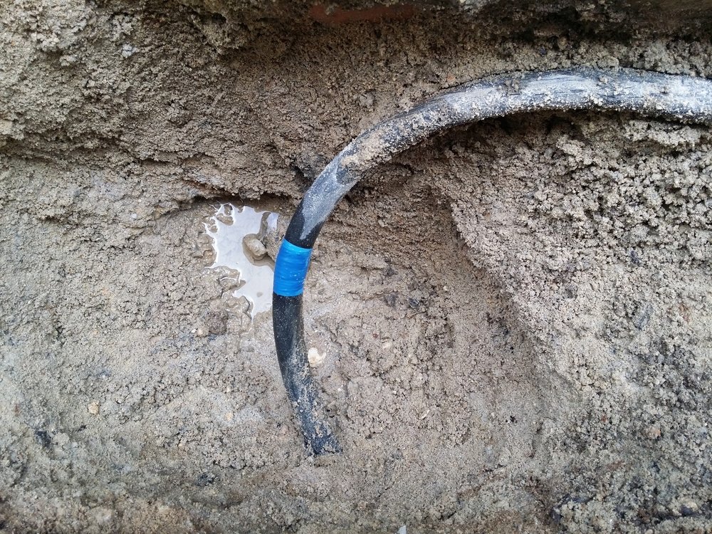 Plumber using leak detection equipment to find a hidden water leak