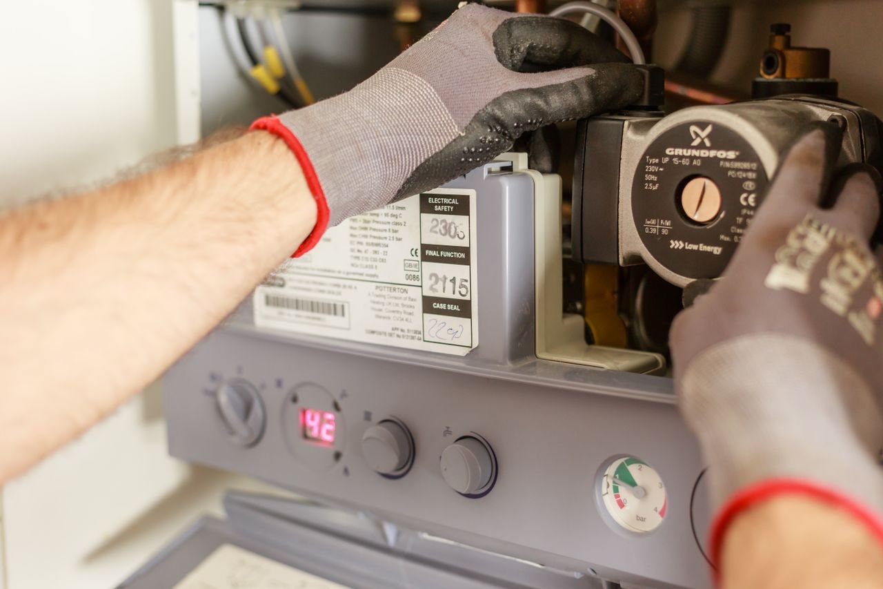 Plumber servicing a geyser unit for emergency repair